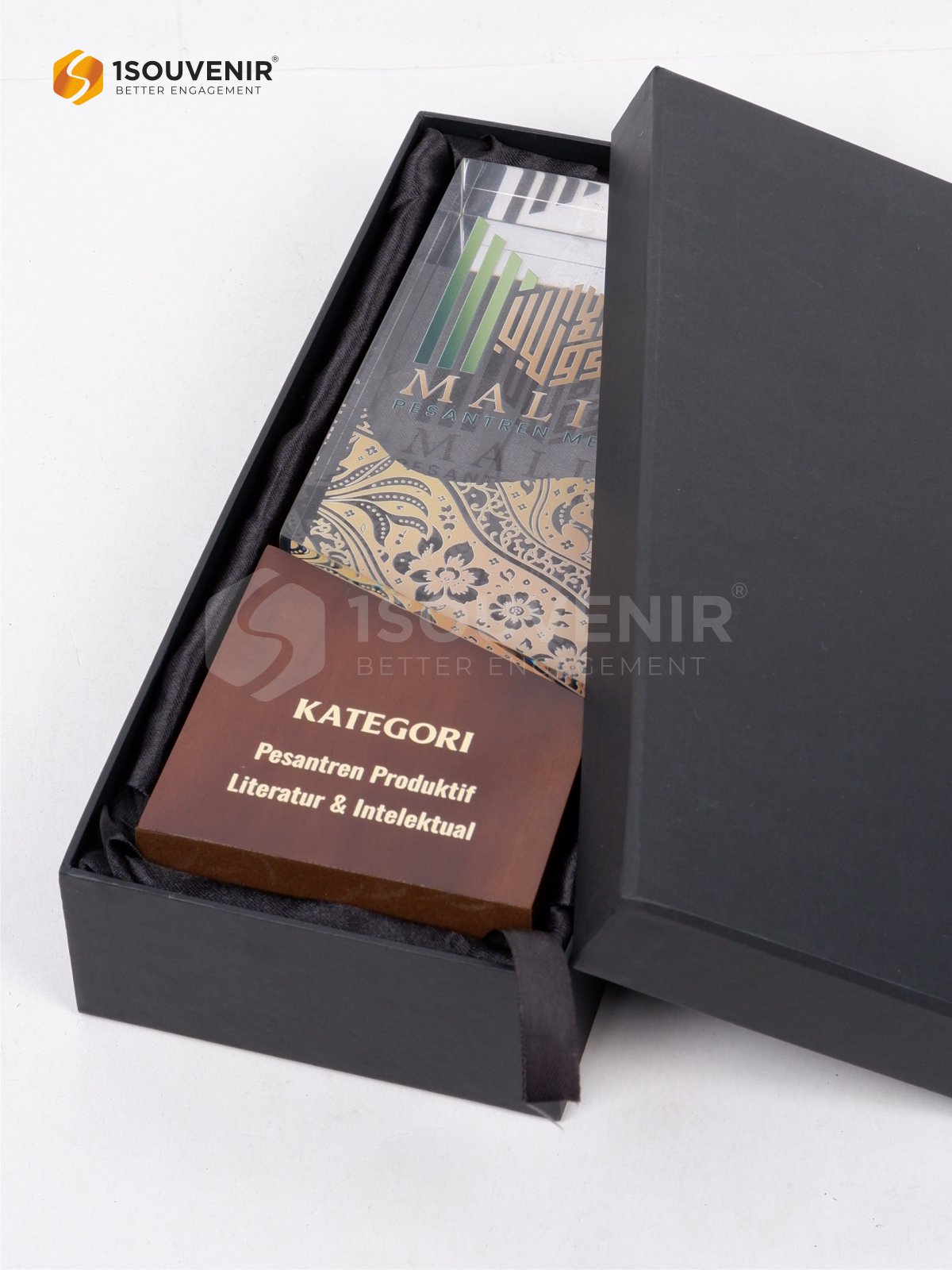 Kotak kemasan hitam dengan lapisan kain satin gelap sebagai pelindung plakat